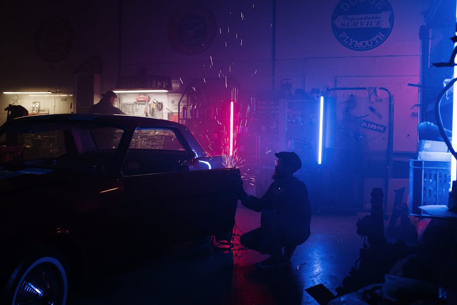 A mechanic repairs a car in a neon-lit garage, creating a unique and vibrant atmosphere.