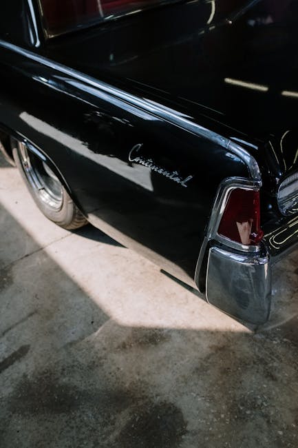 Classic black Lincoln Continental car tail light detail in a garage setting.
